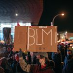 A protester carries a sign reading "BLM" outside the Barclays Center during a demonstration on November 19th criticizing the Kyle Rittenhouse verdict.
